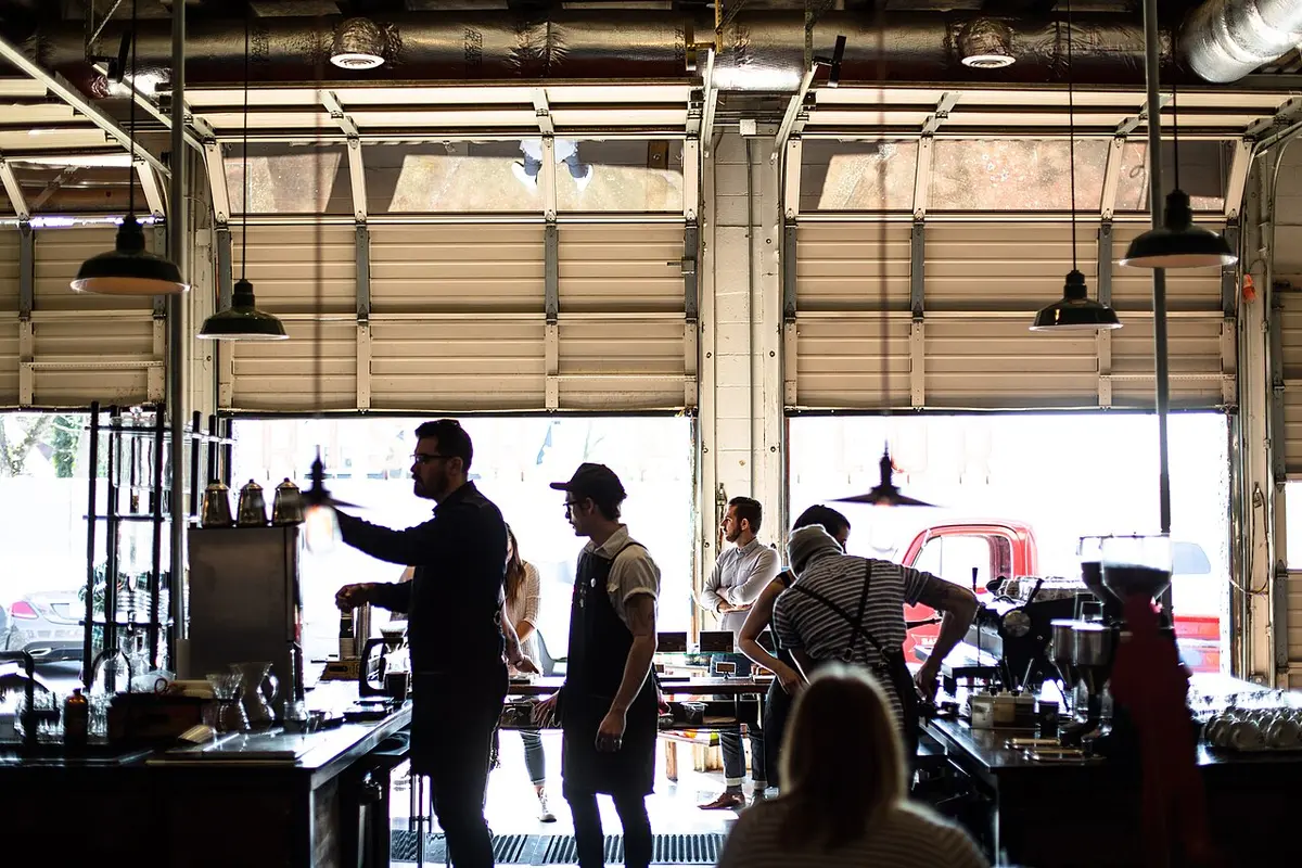 Baristas greeting a regular